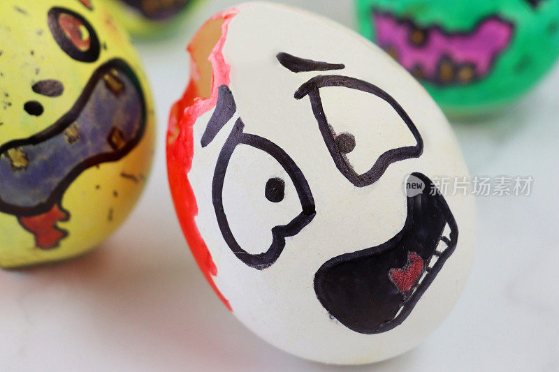 Close-up image of eggs decorated as cartoon monsters capturing egg with drawn scared face, zombie apocalypse pursuit concept, eating brains